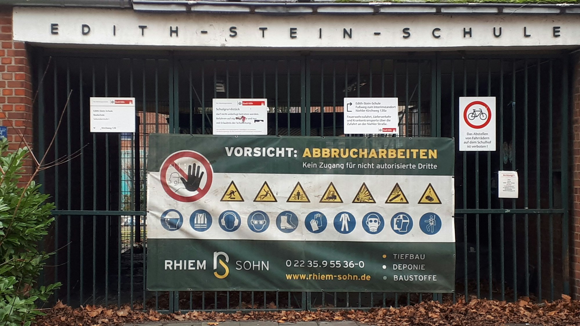 Ein Schild mit „Vorsicht: Abbrucharbeiten“ hängt an dem Tor der Edith-Stein-Realschule am Niehler Kirchweg 120.