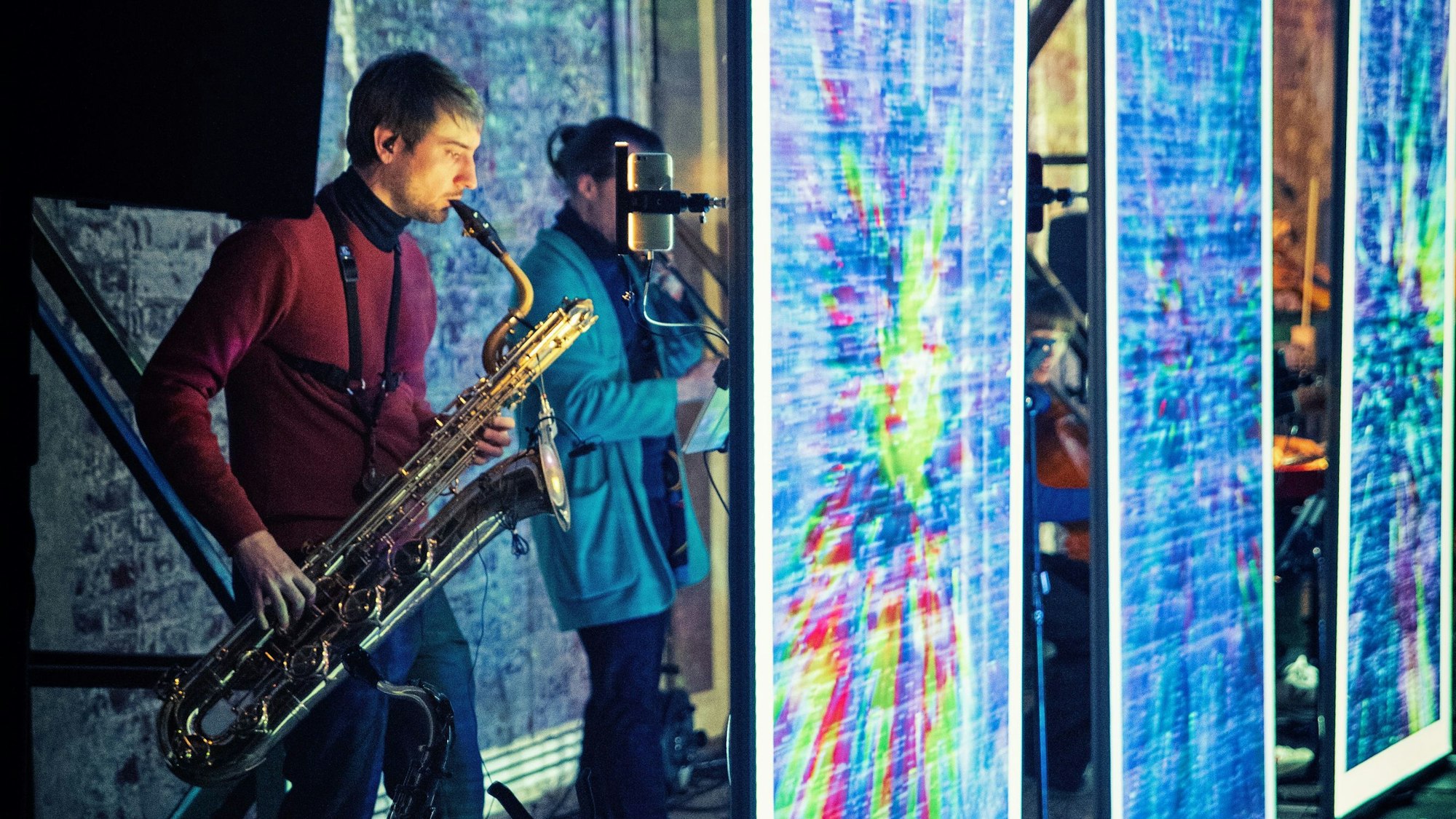 Das Ensemble „Electronic ID“ verschwindet hinter Leinwänden.