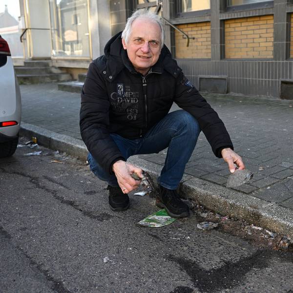Bernd Trauschies kniet am Straßenrand vor herumliegendem Müll.
