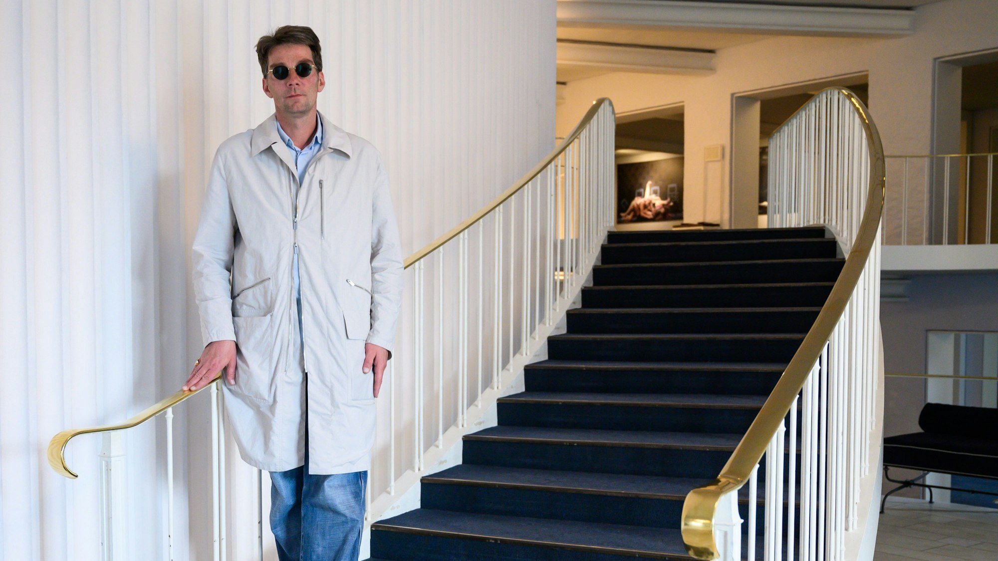 Marco Goecke steht auf den unteren Treppenstufen des Foyers der Staatsoper Hannover.