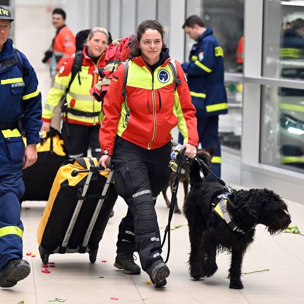 Rettungskräfte werden von jubelnden Menschen auf dem Flughafen in Köln begrüßt.