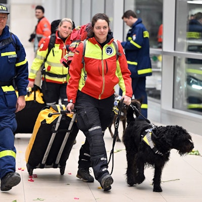 Rettungskräfte werden von jubelnden Menschen auf dem Flughafen in Köln begrüßt.