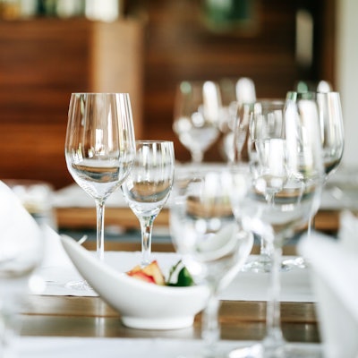 Ein gedeckter Tisch mit Gläsern und Porzellan.