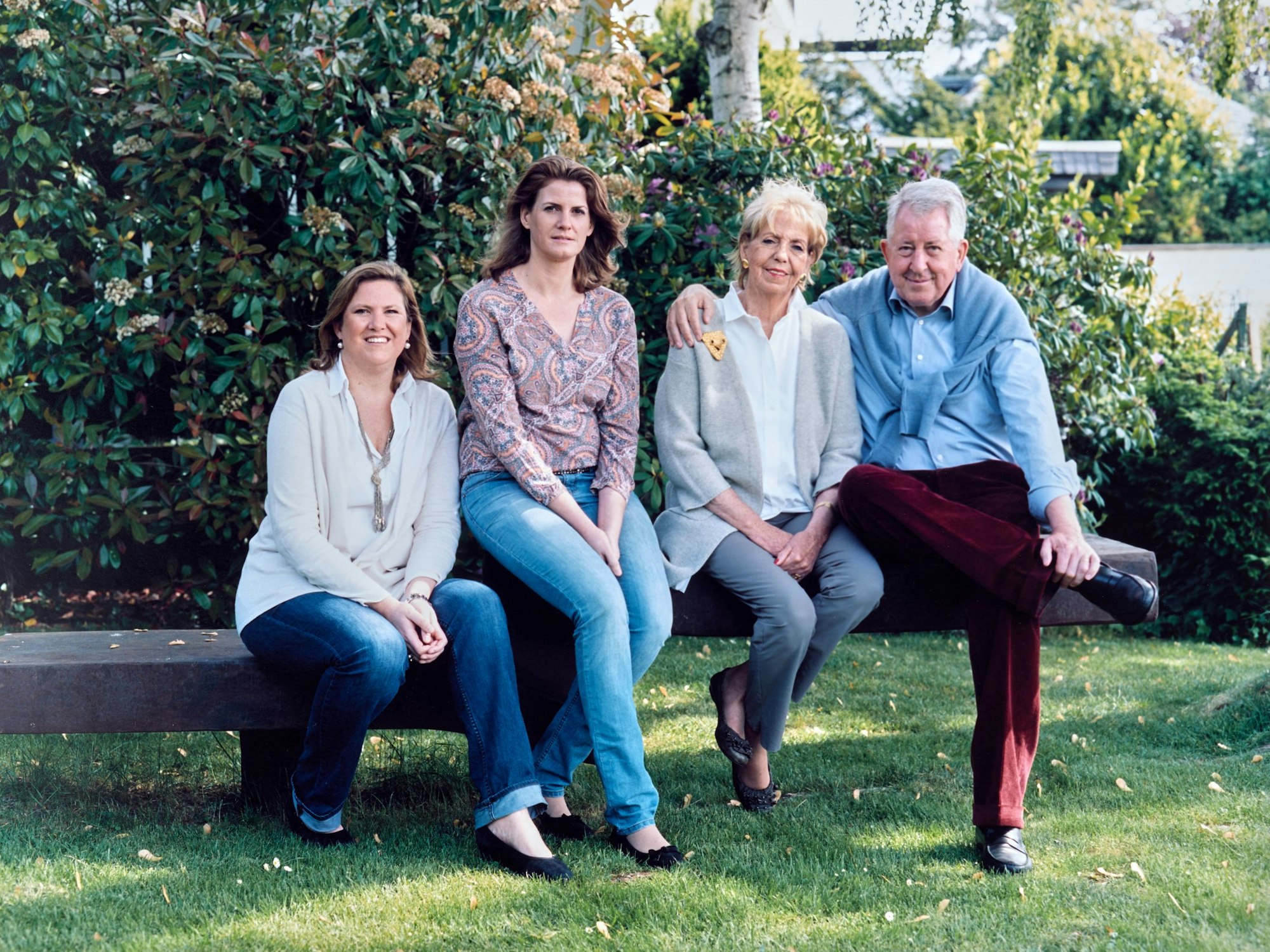 Die vierköpfige Familie Bartenbach sitzt in einem Garten nebeneinander auf einer Bank.