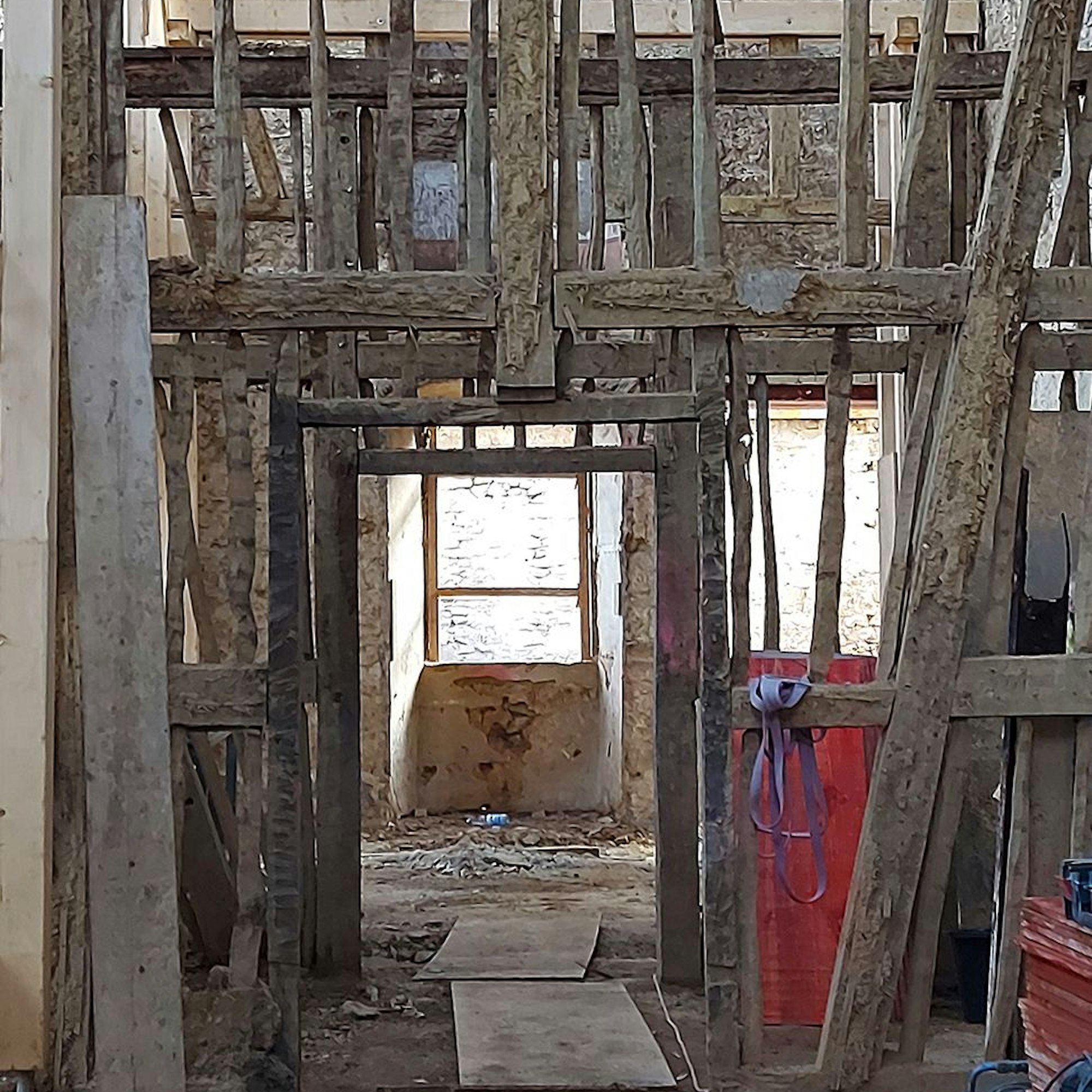 Ein altes Haus wird saniert und ist fast komplett entkernt. Nur Fachwerk-Balken stehen noch.