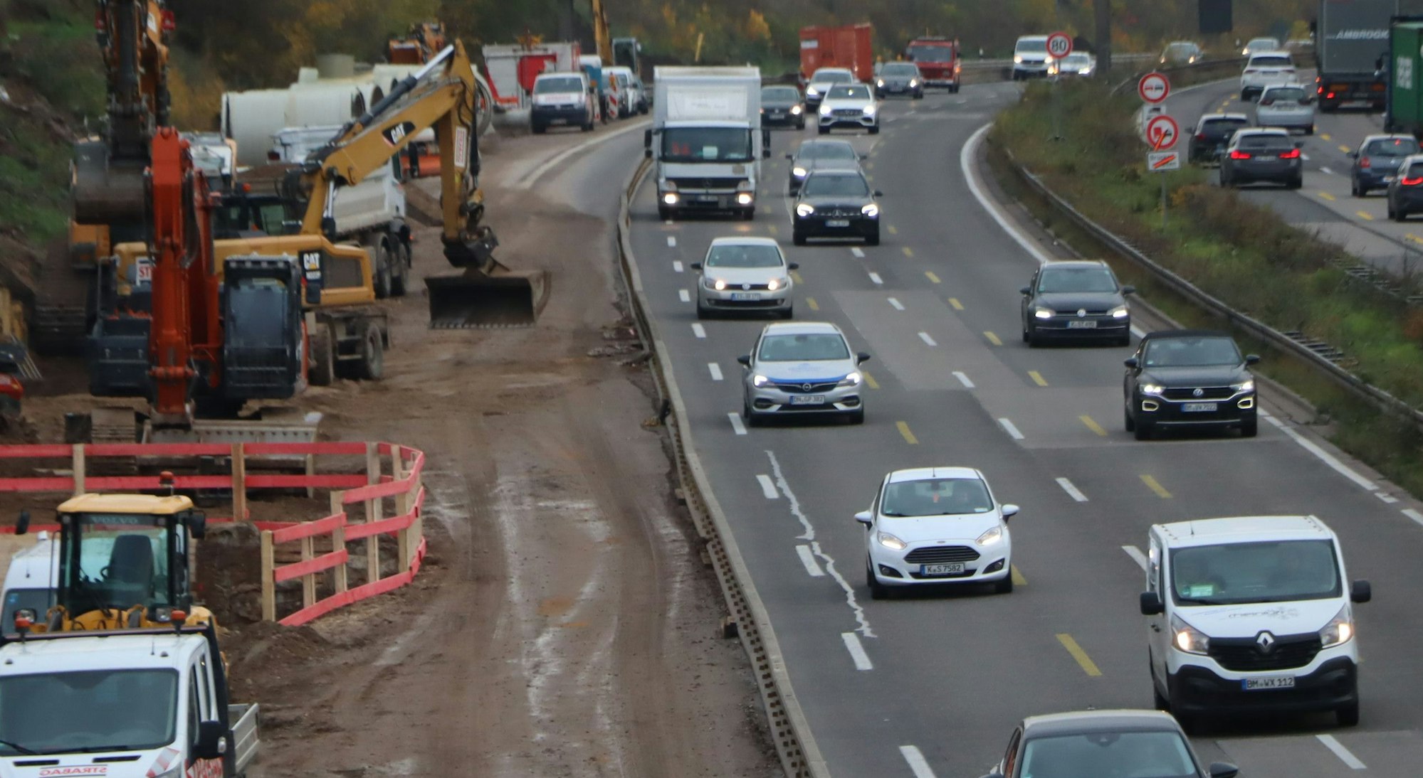 Das Foto zeigt die Bauarbeiten an der A 555 bei Wesseling. Der Verkehr läuft zwar weiter, neben den Fahrspuren ist jedoch schweres Baugerät zu sehen.