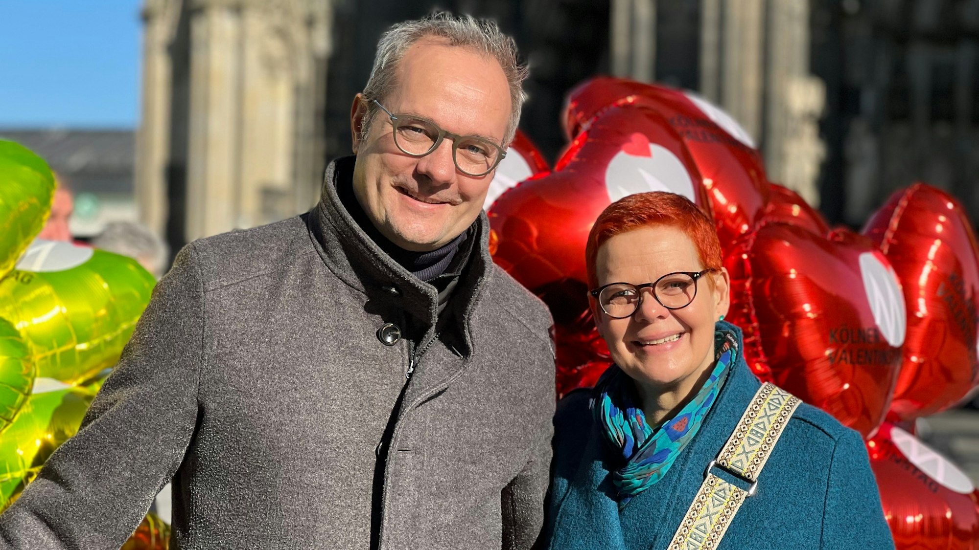 Britta Kallius und Tim Endemann mit Herzluftballons im Hintergrund.