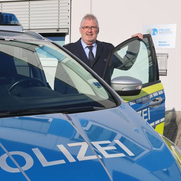 Der neue Wachleiter Falko Steinhauer steht an einem Streifenwagen.
