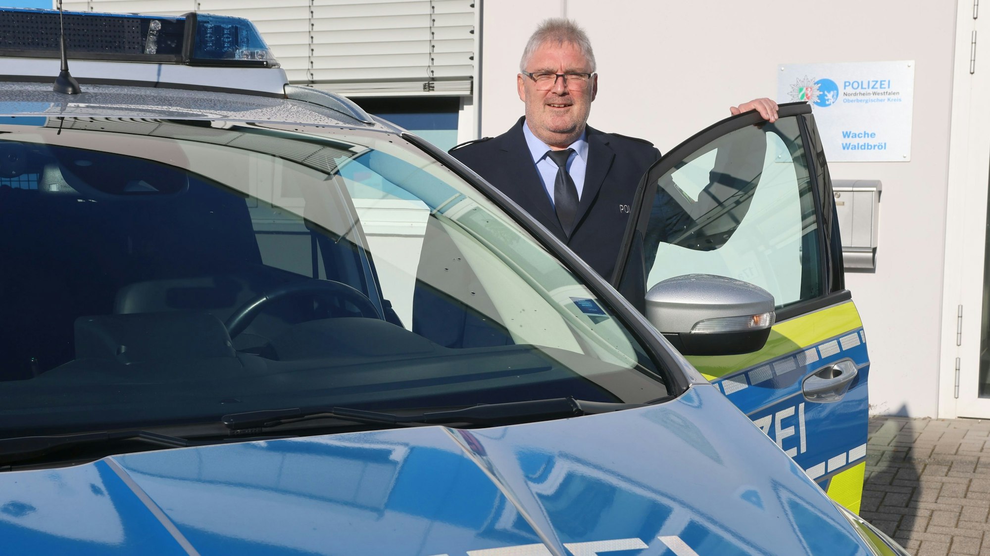 Der neue Wachleiter Falko Steinhauer steht an einem Streifenwagen.