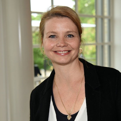 Schauspielerin Annette Frier steht in der Kölner Flora, sie lacht in die Kamera und trägt einen schwarzen Blazer