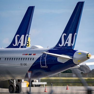 Zwei Airbus A320 der norwegischen Fluggesellschaft SAS stehen neben einer gelben Passagiertreppe. (Symbolbild)