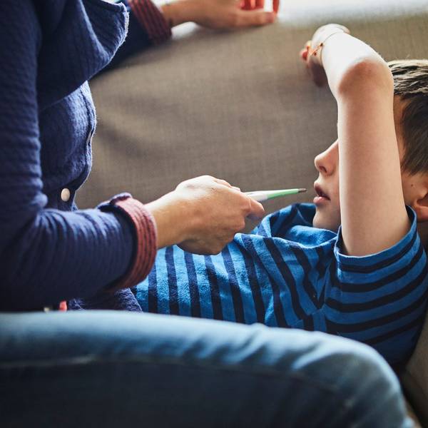 Eine Mutter misst Fieber bei ihrem kranken Sohn.