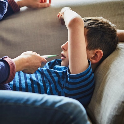 Eine Mutter misst Fieber bei ihrem kranken Sohn.