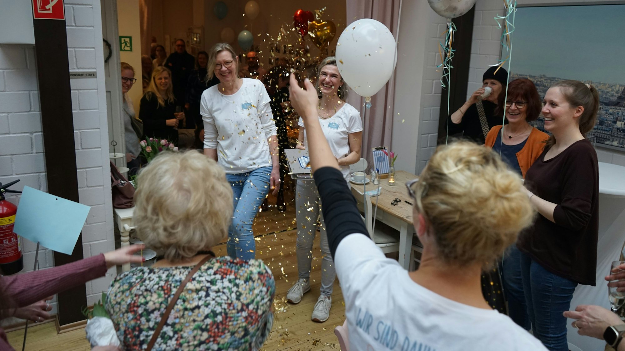Daniklea Herbst (links) und Christina Kombüchen unter dem goldenen Regen der Mitarbeiterinnen.