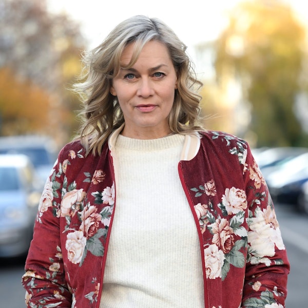 Gesine Cukrowski steht mit einem weißen Pullover und einer geblümten Jacke in ihrem Berliner Kiez.