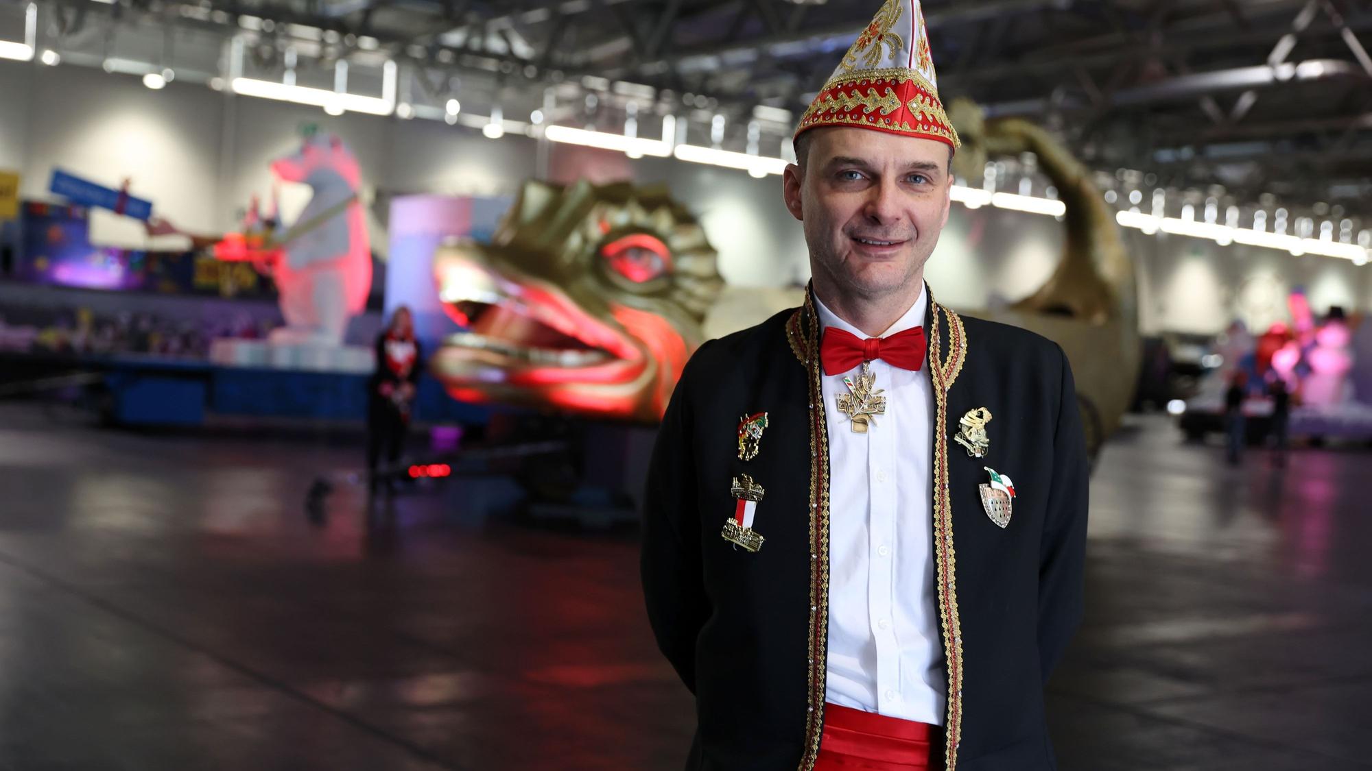 Holger Kirsch steht in der Messehalle vor Persiflagewagen