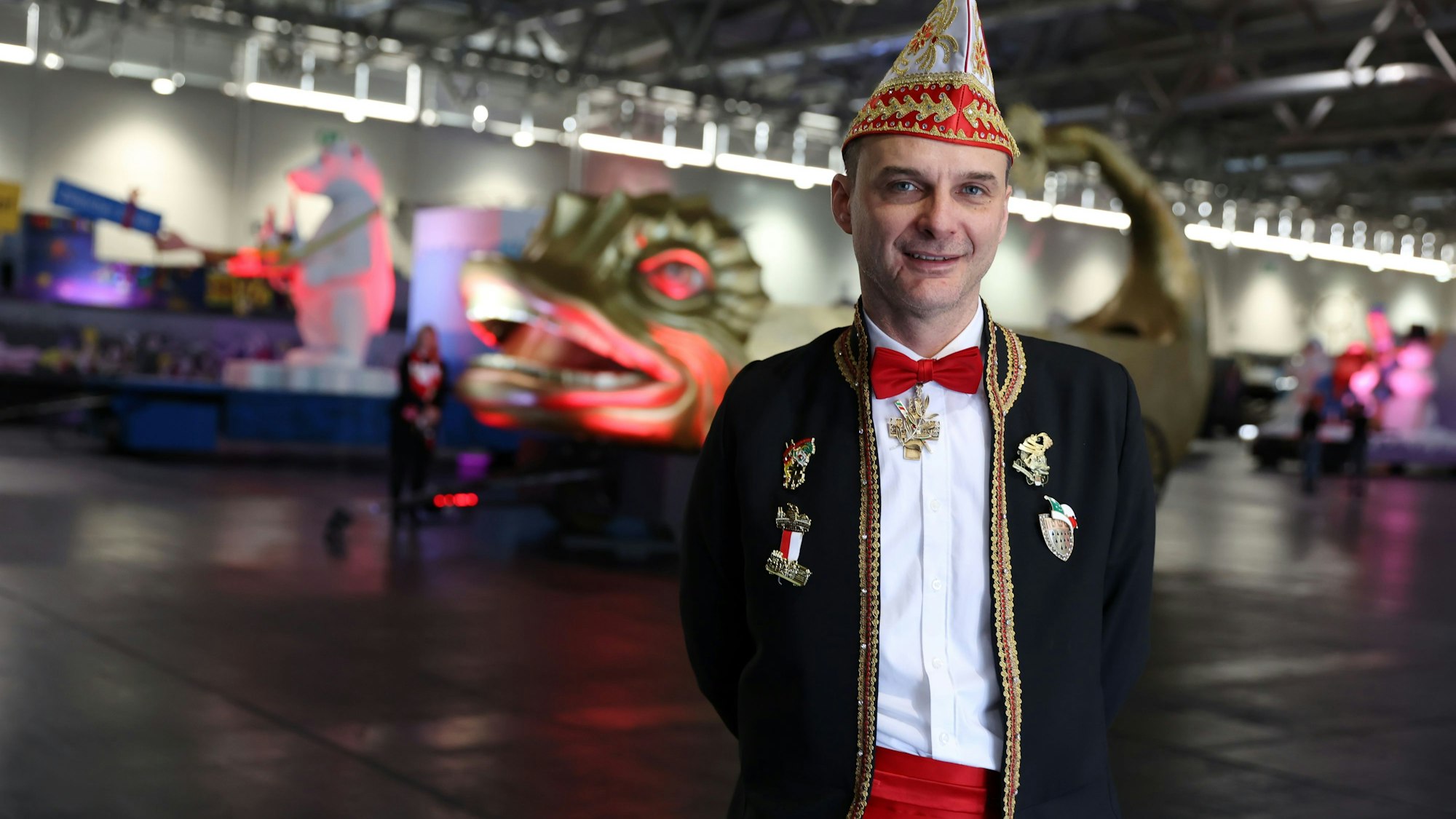 Holger Kirsch steht in der Messehalle vor Persiflagewagen