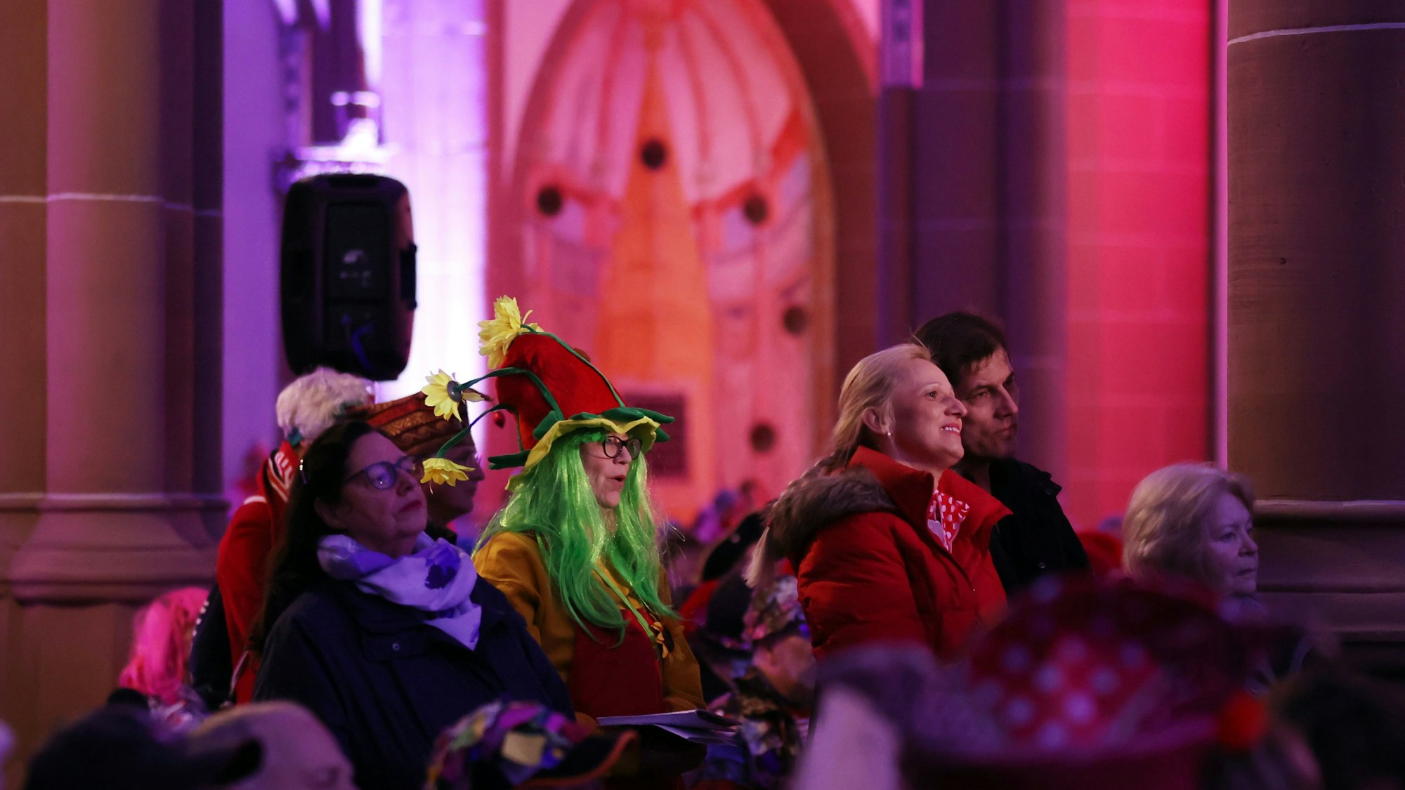 Mehrere Besucher und Besucherinnen sind verkleidet und schauen nach vorne.