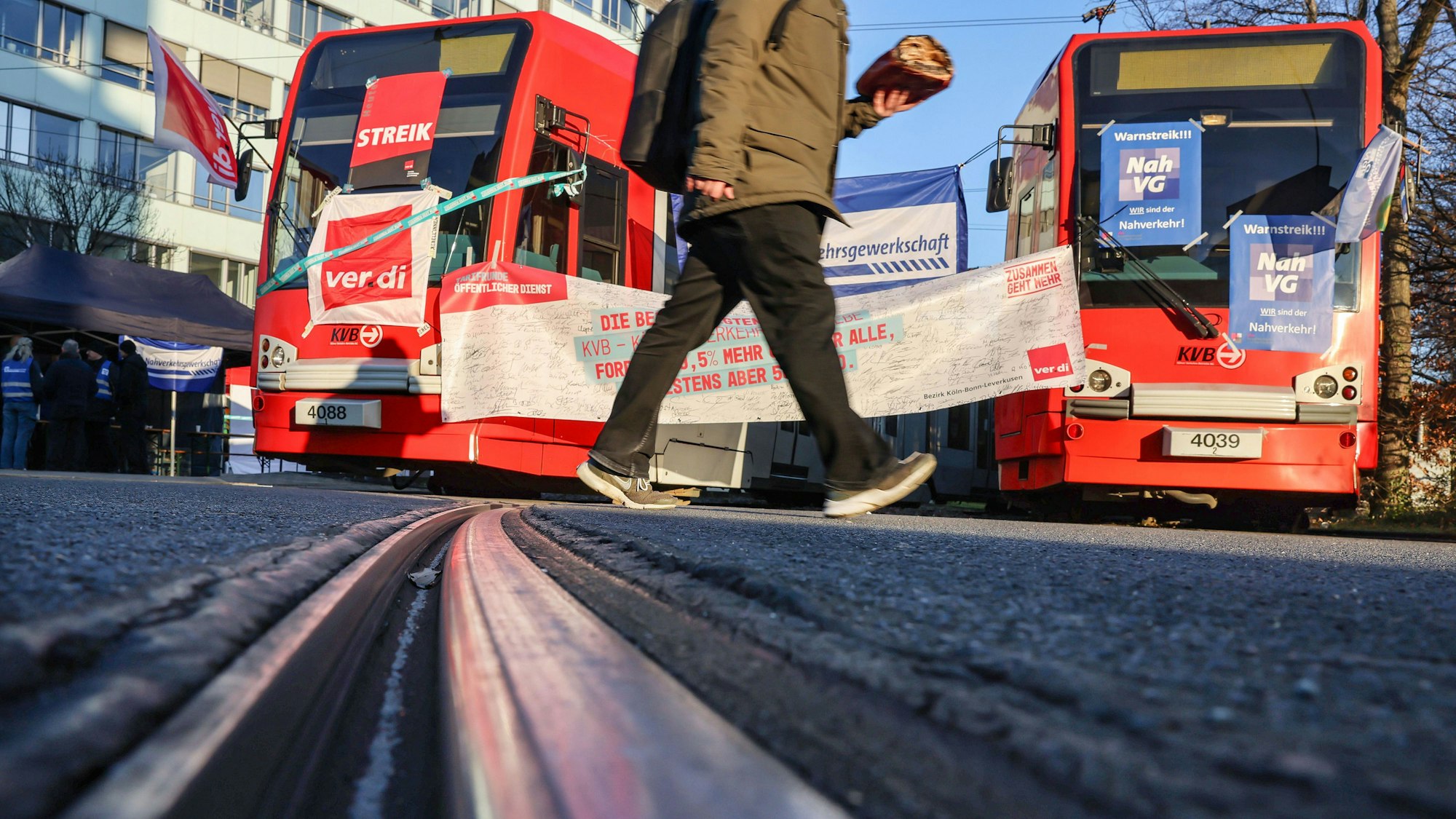 Mit Streik-Plakaten beklebte Straßenbahnen der Kölner Verkehrs-Betriebe (KVB) stehen vor dem Bahndepot.
