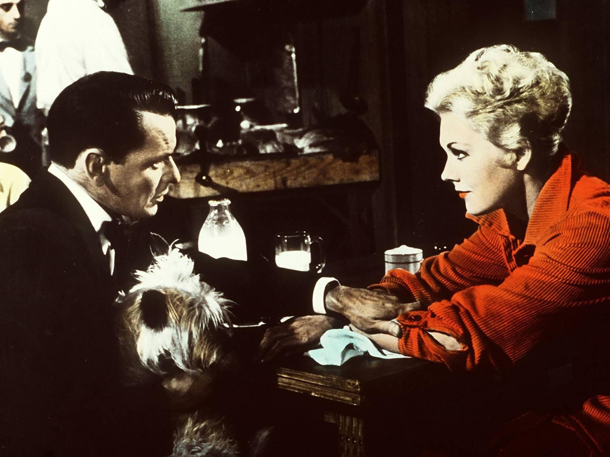Frank Sinatra und Kim Novak sitzen an einem Tisch.