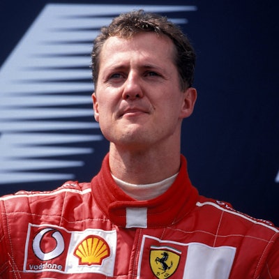 Michael Schumacher steht nach einem Rennen in der Box und schaut in die Ferne.