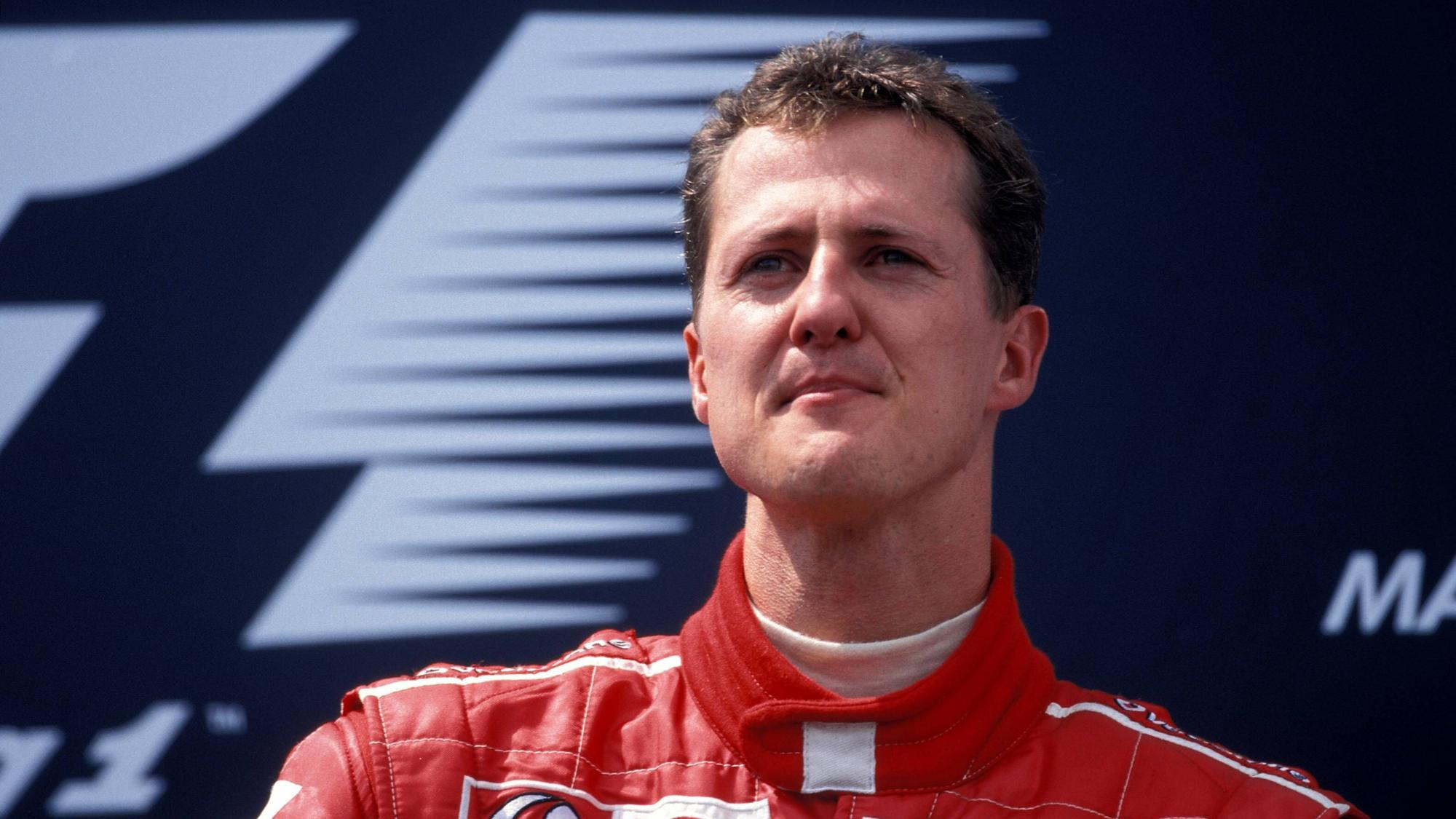 Michael Schumacher steht nach einem Rennen in der Box und schaut in die Ferne.