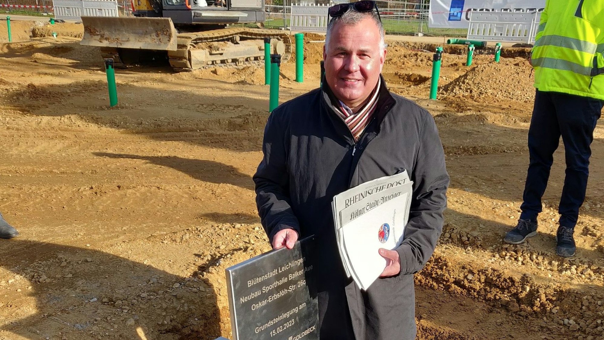 Bürgermeister Frank Steffes steht mit Dokumenten für den Grundstein an der offenen und noch leeren Metallkassette.