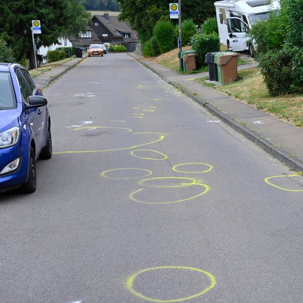 Auf einer Straße sind zahlreiche gelbe Markierungen der Polizei zu sehen.