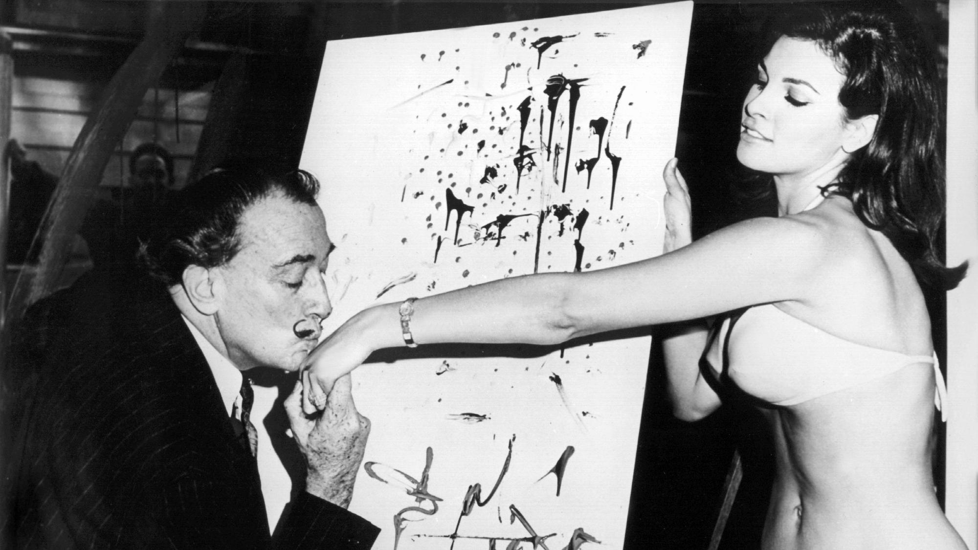 Der spanische Maler Salvador Dali küsst Raquel Welch die Hand, während sie dem Künstler im Schaufenster eines New Yorker Geschäftes Modell steht (Aufnahme August 1966).