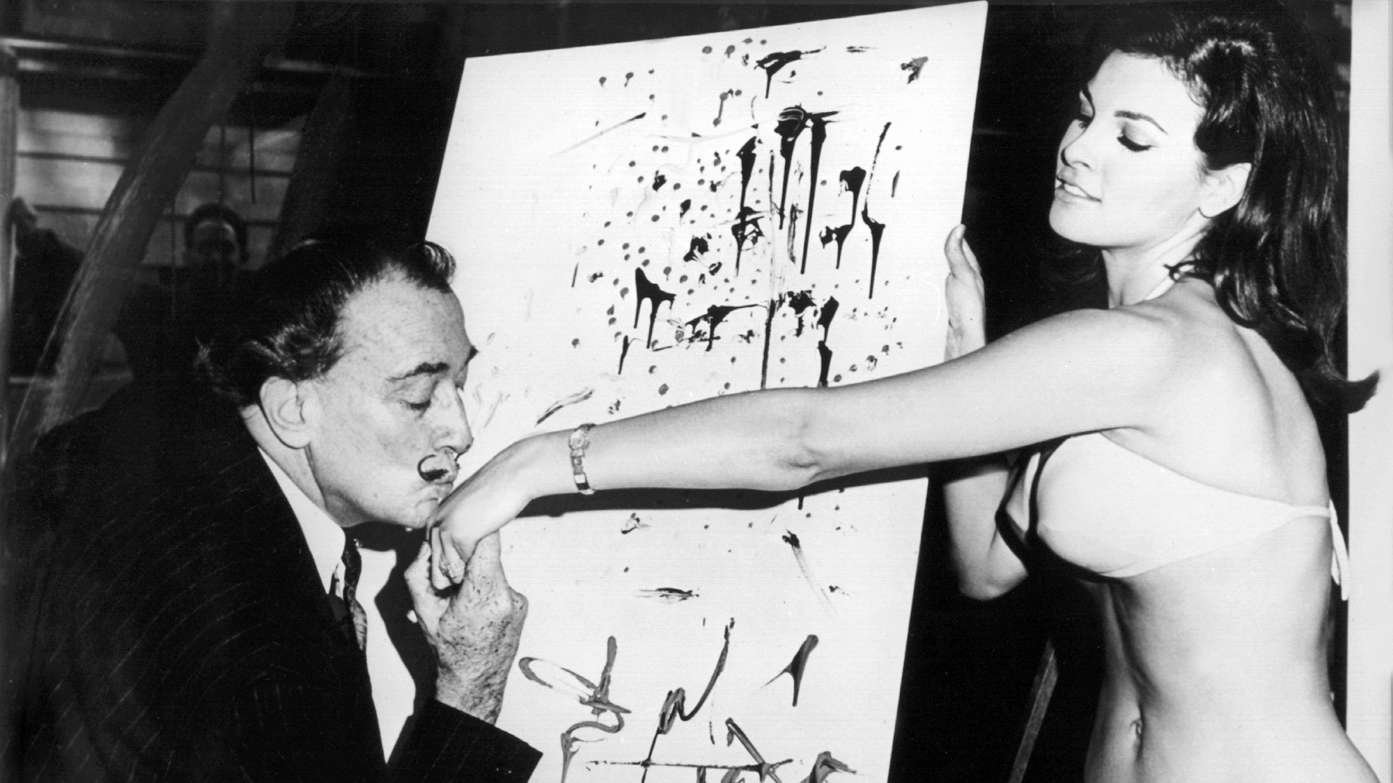 Der spanische Maler Salvador Dali küsst Raquel Welch die Hand, während sie dem Künstler im Schaufenster eines New Yorker Geschäftes Modell steht (Aufnahme August 1966).