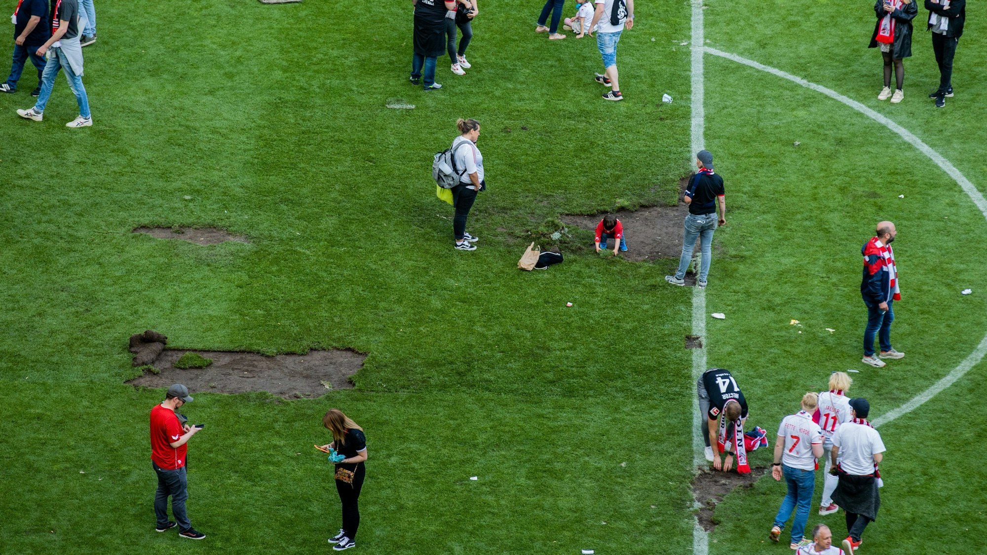 07.05.2022, Nordrhein-Westfalen, Köln: Fußball: Bundesliga, 1. FC Köln - VfL Wolfsburg, 33. Spieltag, RheinEnergieStadion. Kölner Fans haben den Platz gestürmt und Rasen mitgenommen.