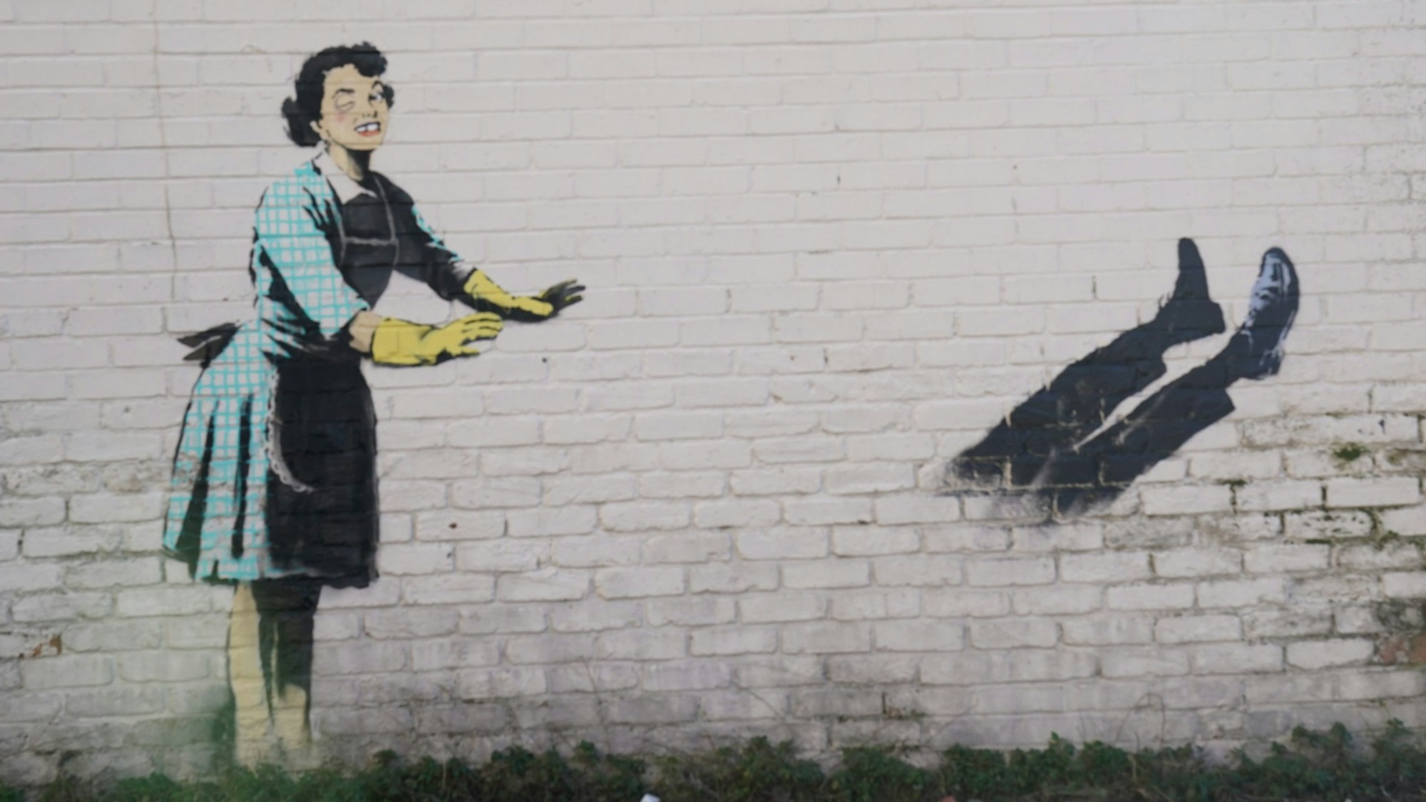 Das neue Kunstwerk des Straßenkünstlers Banksy mit dem Titel „Valentine's Day Mascara“ an der Seite eines Gebäudes wurde von einer Gefriertruhe und zerbrochenen Möbeln, die Teil der Installation waren, befreit. Das Kunstwerk zeigt eine Hausfrau aus den 1950er Jahren, die eine klassische blaue Krawatte und gelbe Spülhandschuhe trägt, mit einem geschwollenen Auge und einem fehlenden Zahn, die ihren männlichen Partner in eine Gefriertruhe zu schubsen scheint.