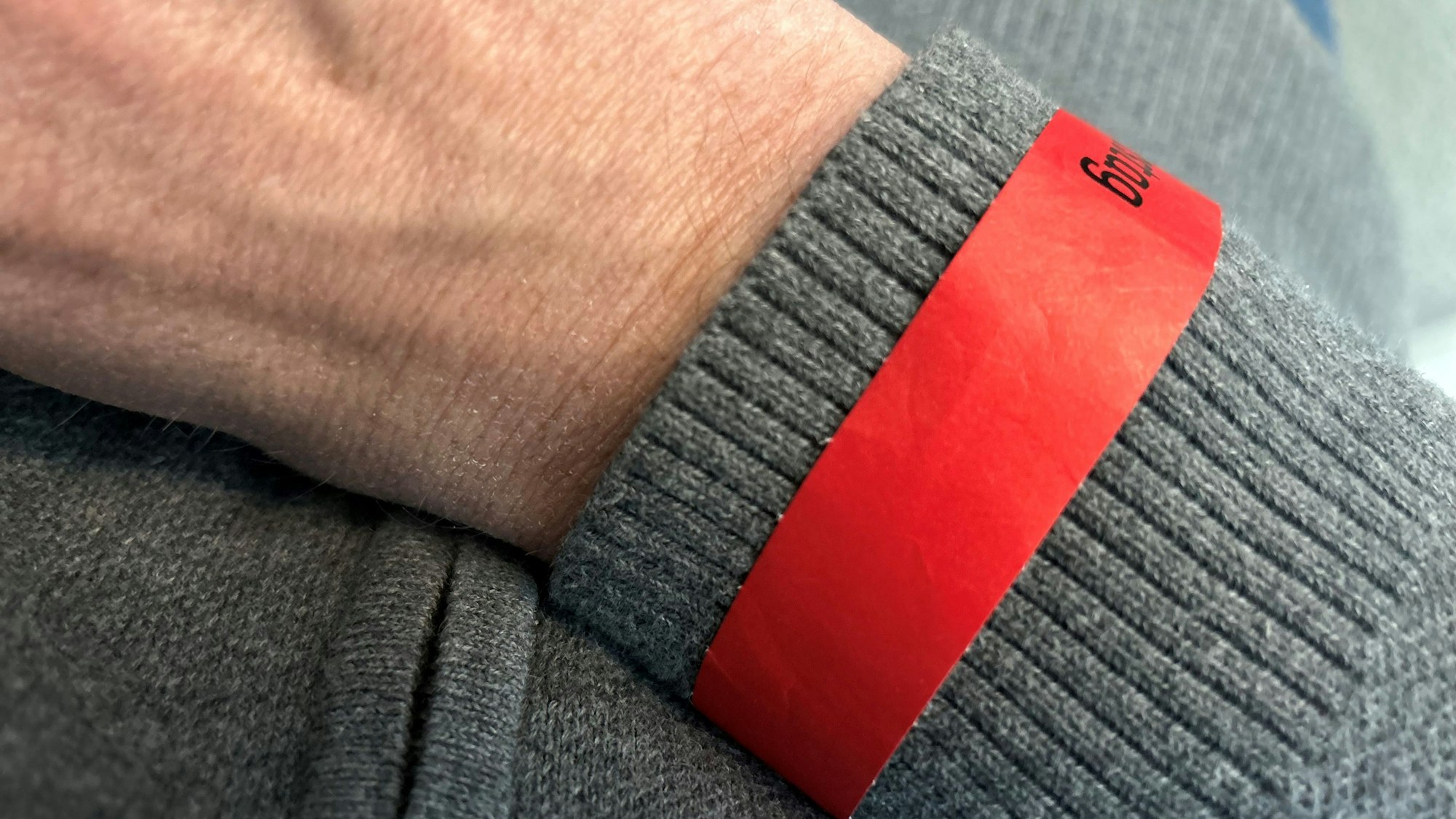 Offizielles, rotes Zutrittsbändchen für Weiberfastnacht an einem Arm