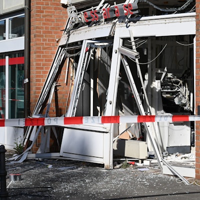 Ein zerstörter, explodierter Geldautomat an der Dürener Straße hinter rot-weißem Absperrband.