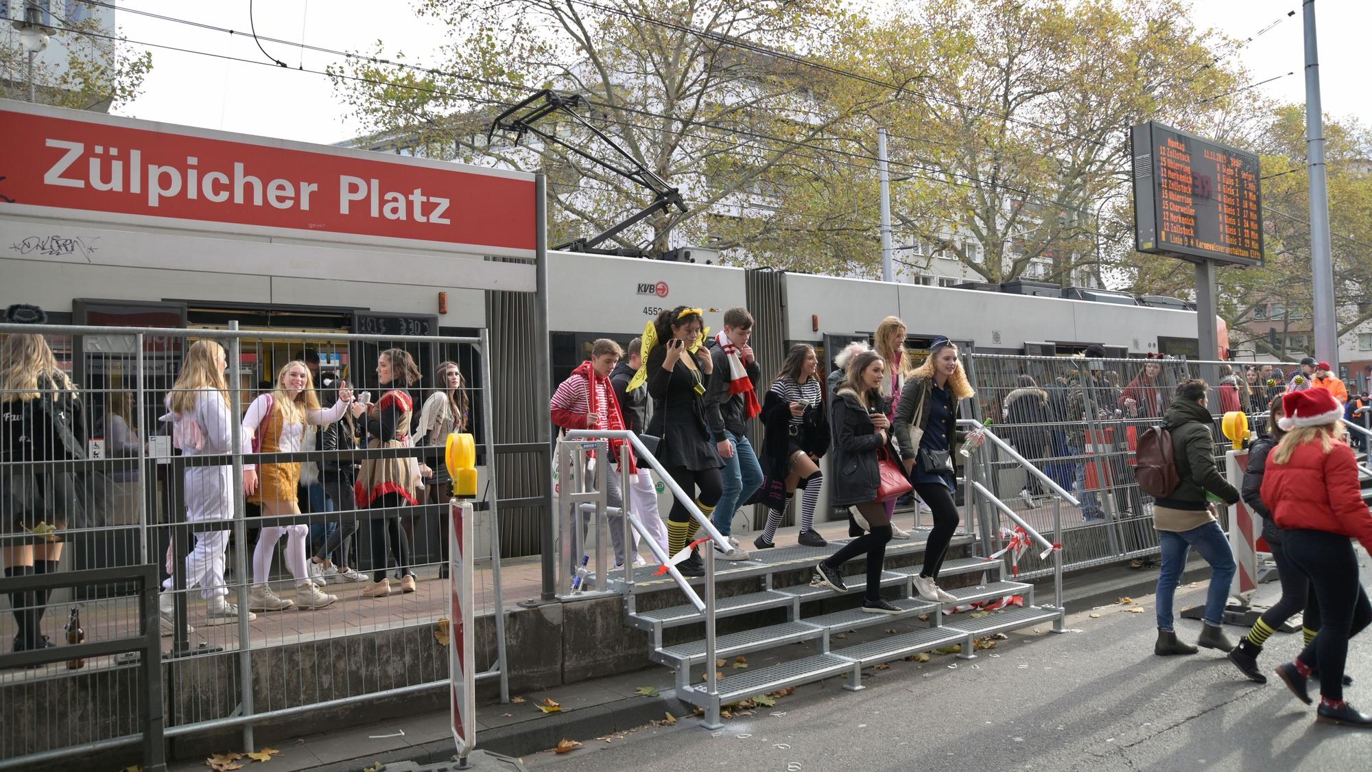 Mehrere Feiernde steigen aus einer Stadtbahnlinie der KVB aus.