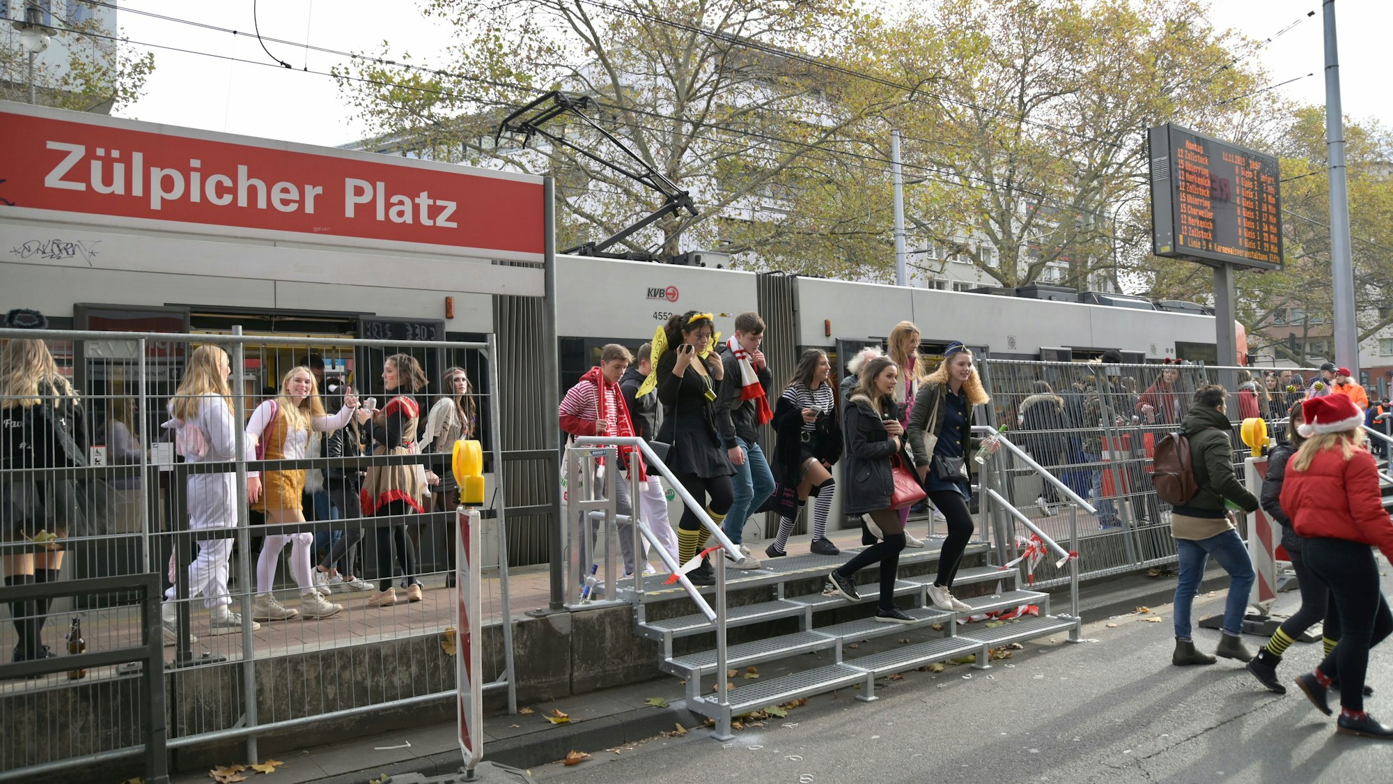 Mehrere Feiernde steigen aus einer Stadtbahnlinie der KVB aus.