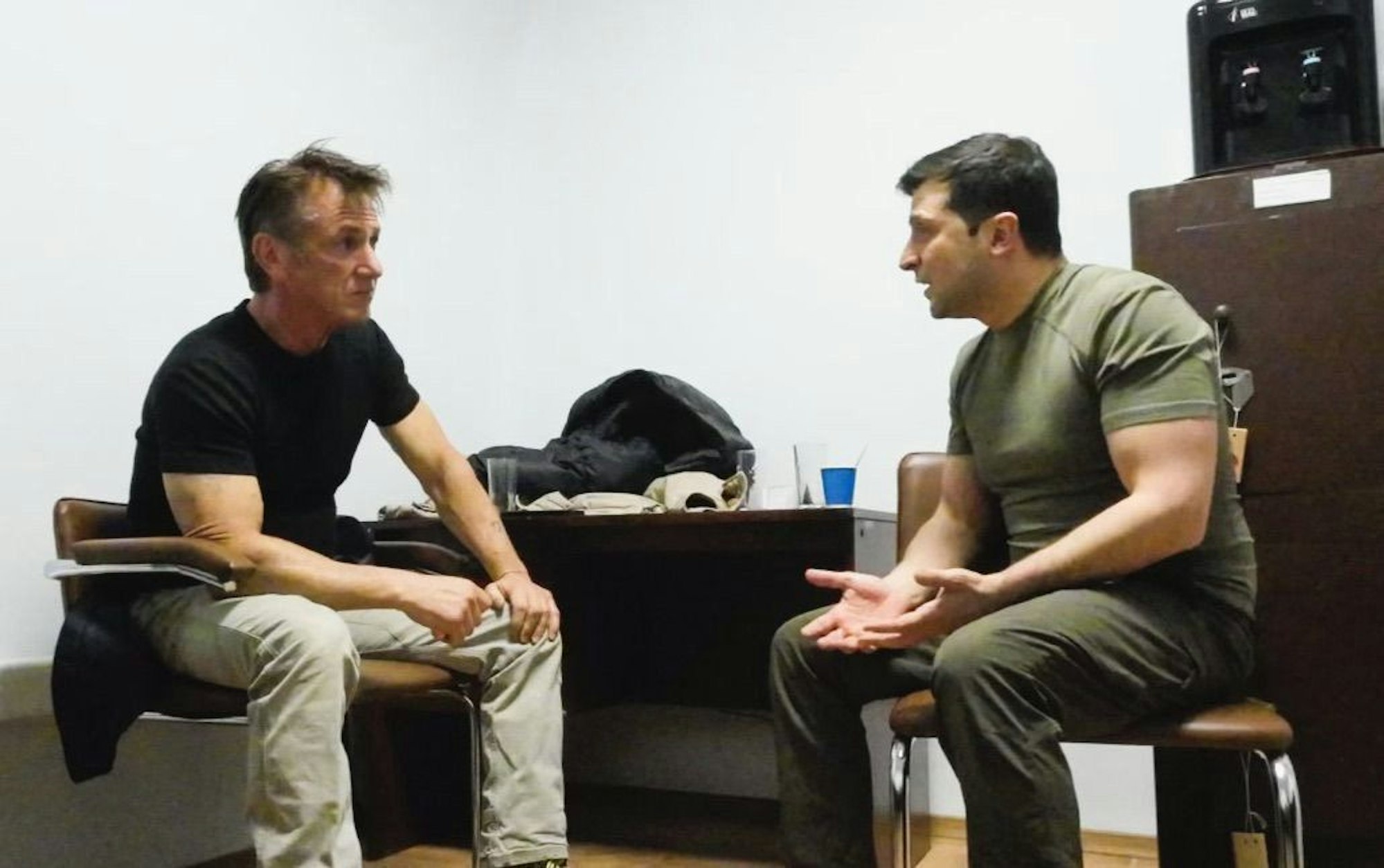 Sean Penn (l) und der ukrainische Präsident Wolodymyr Selenskyj sitzen sich gegenüber. Der ukrainische Präsidentz trägt armeegrüne Kleidung.