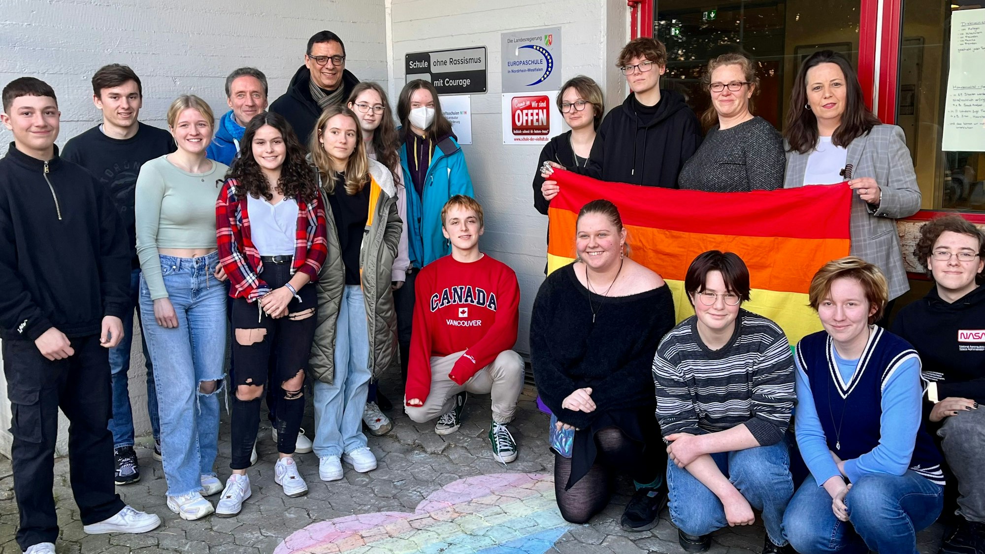 Gruppe von Schülern und Lehrerinnen vor der neuen Plakette