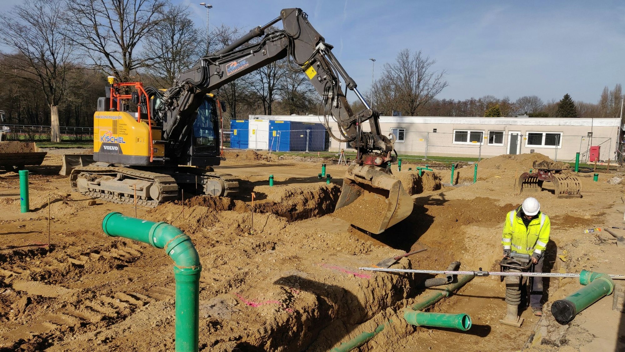 Bagger und Bauarbeiter bei Erdarbeiten.