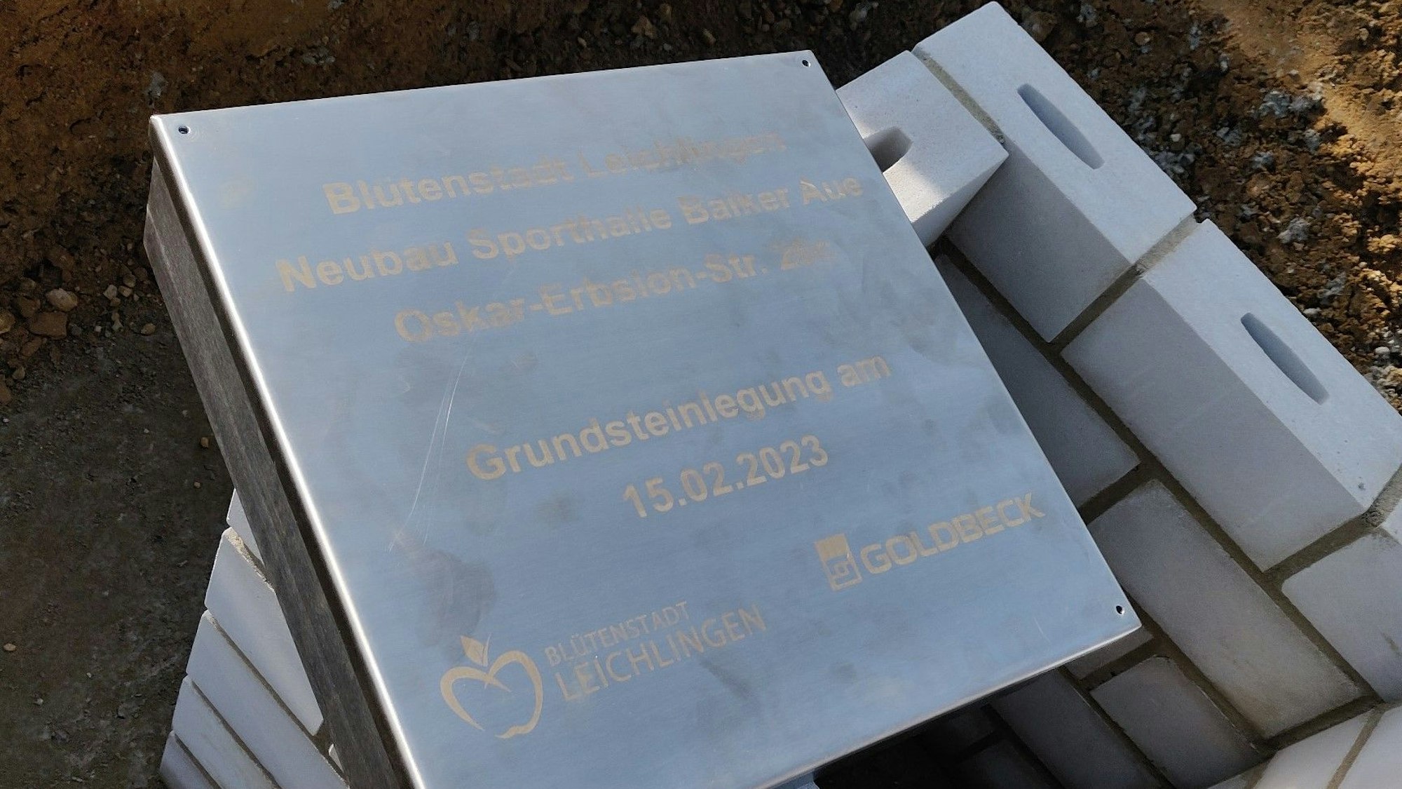 Der gravierte Deckel der Kassette enthält die Daten der Grundsteinlegung und die Adresse der neuen Sporthalle: Oskar-Erbslöh-Straße 26c.