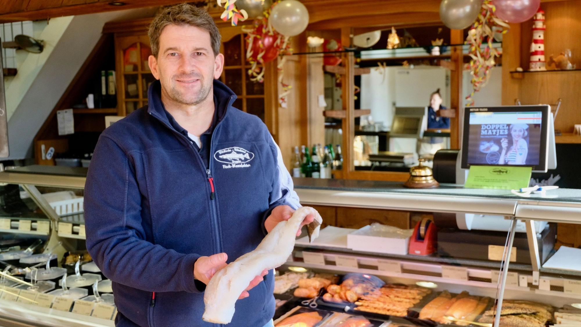 Der Besitzer des Fischladens Bremer präsentiert ein Fischfilet.