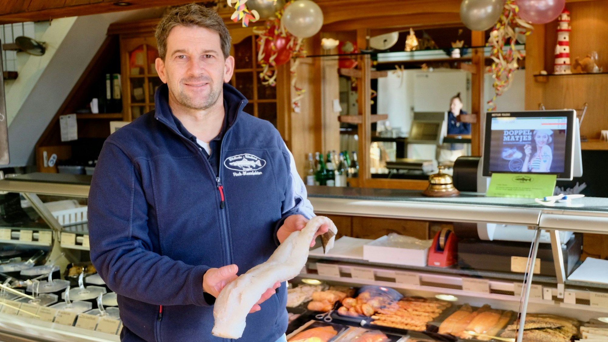 Der Besitzer des Fischladens Bremer präsentiert ein Fischfilet.