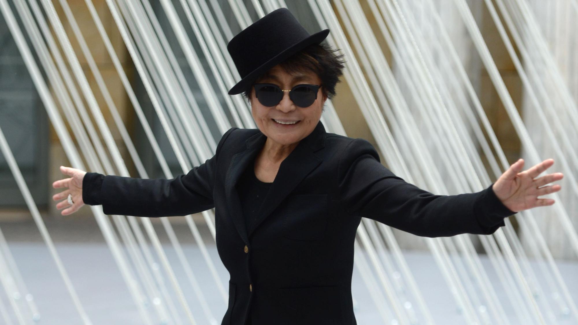 Yoko Ono ganz in Schwarz mit Hut.