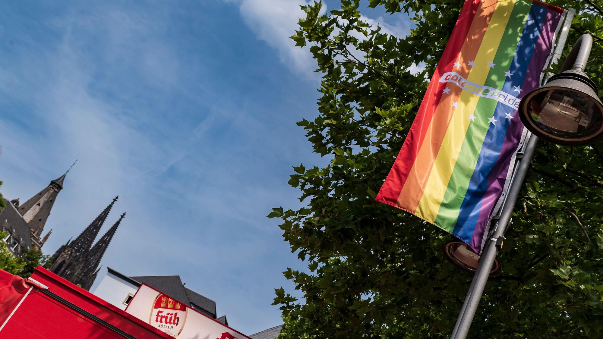Eine Cologne Pride Fahne in Köln, im Hintergrund ist der Dom zu sehen. (Archivbild)