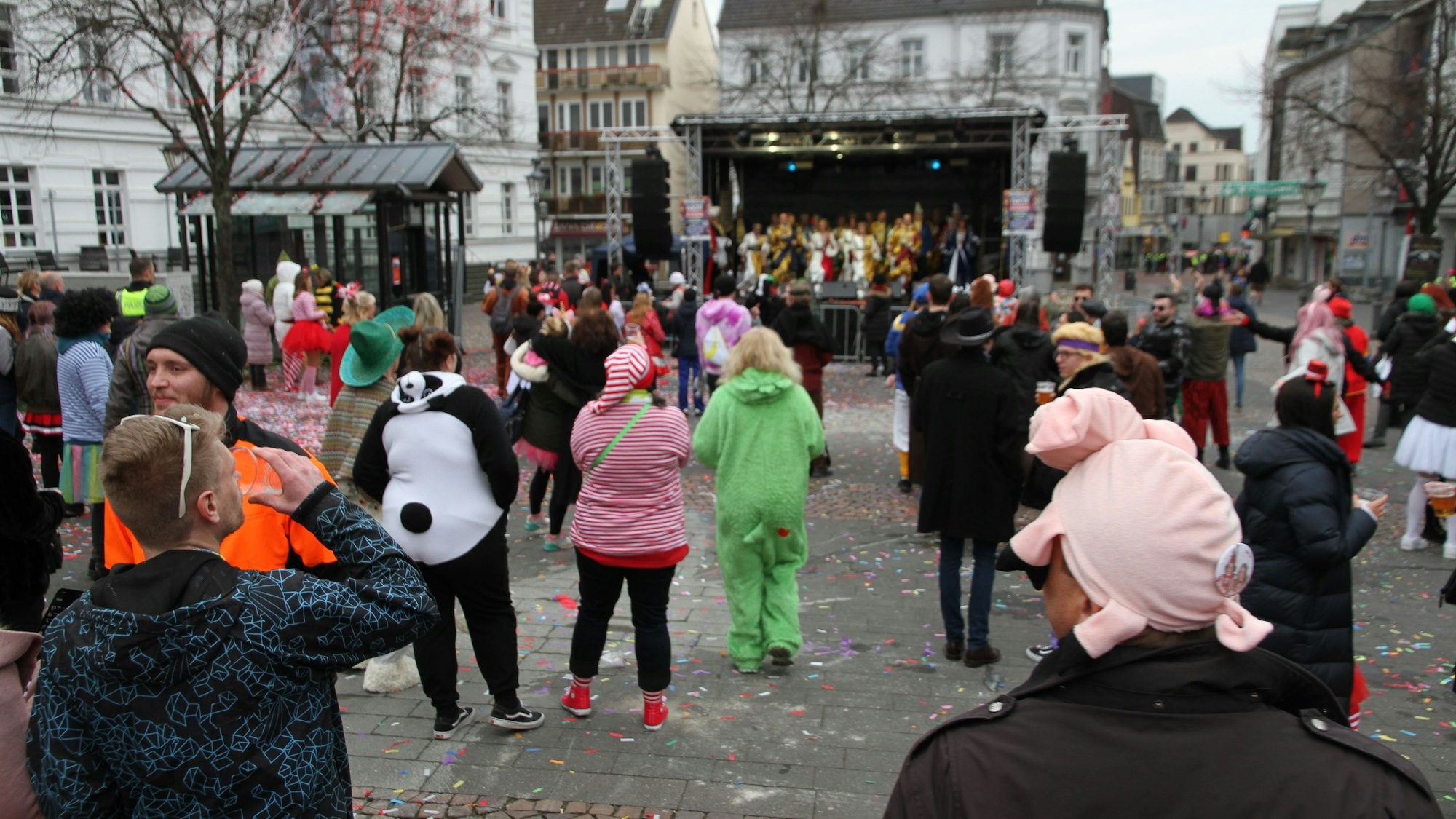 Kostümierte feiern Weiberfastnacht auf einem Marktplatz