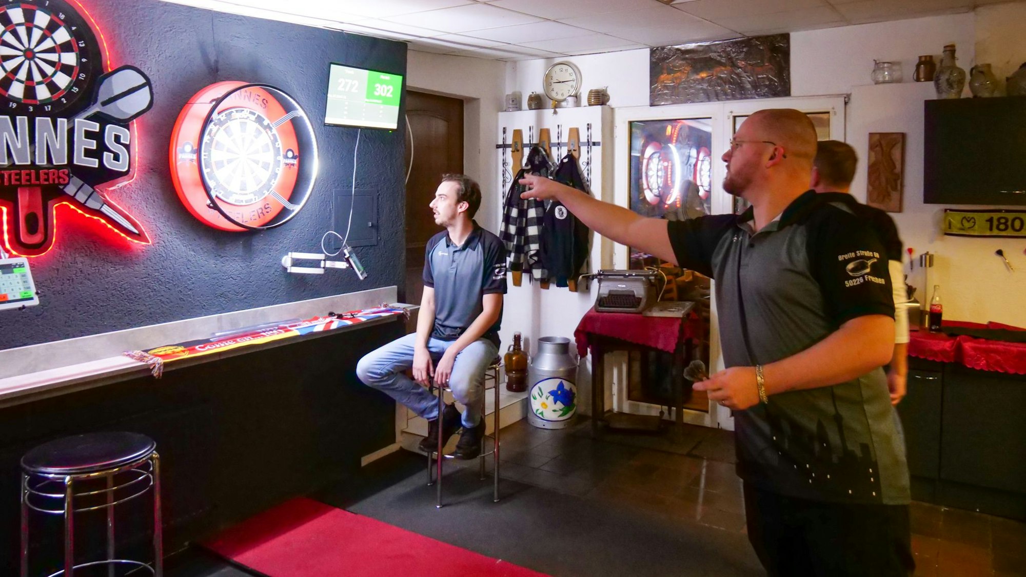 Ein Mann wirft einen Pfeil auf die Dartscheibe.