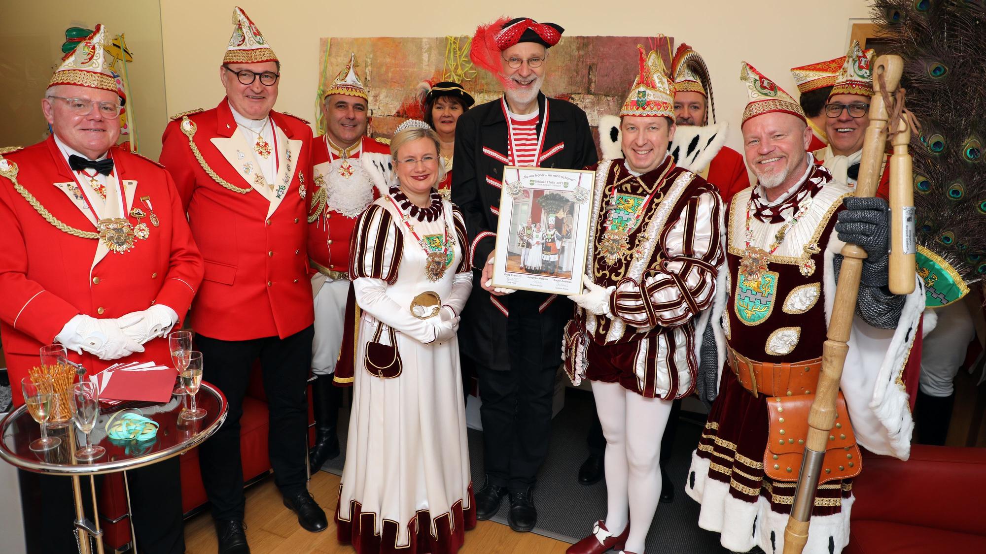 Bergisch Gladbachs Dreigestirn überreicht ein Bild an Weihbischof Ansgar Puff, der als Pirat kostümiert ist.