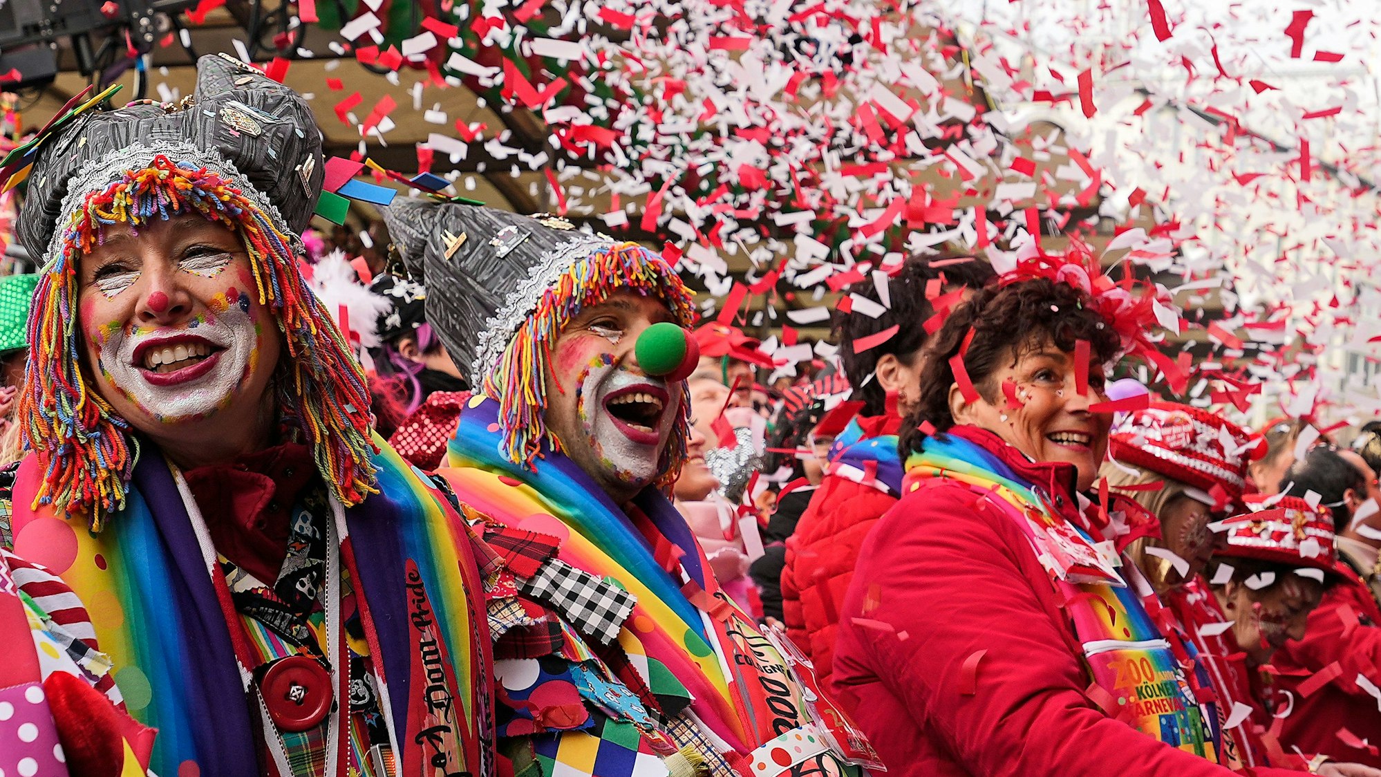 Jecke Kölner feiern die Eröffnung des Straßenkarnevals am Alter Markt im Konfettiregen.