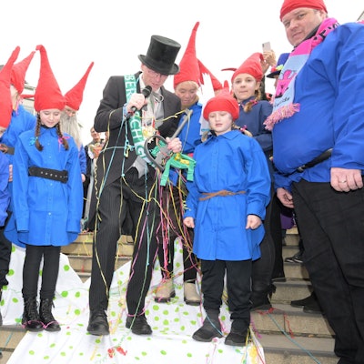 Der Bürgermeister steht zwischen den kleinen Heinzelmännchen