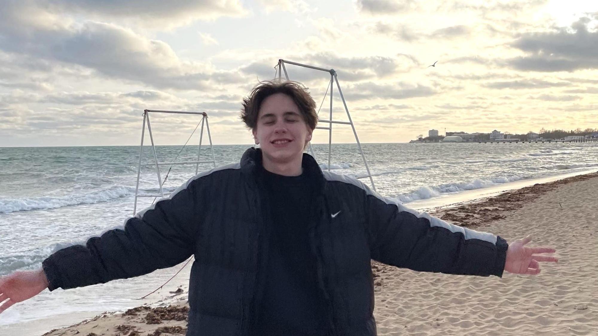 Tristan steht am Strand der Halbinsel Krim und breitet die Arme aus.